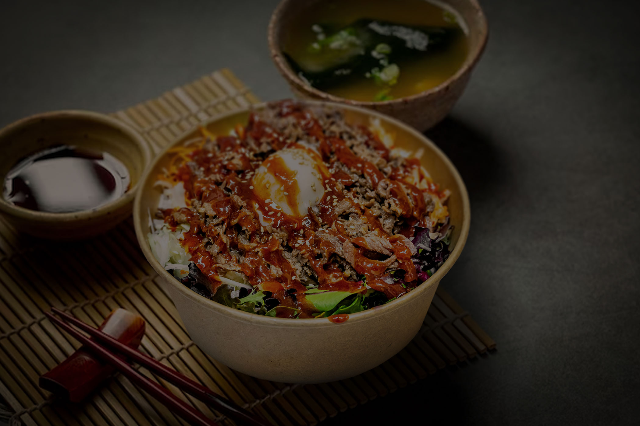 Korean rice bowl with egg, vegetables and gochujang sauce, with soup and side dishes